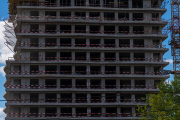 Close-up side view of dark concrete wall of modern skyscraper building under construction. Copy space. Abstract construction background. Housing development theme. © Андрей Рыков