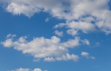 Blue sky with white clouds, close-up of clouds in the upper left corner, sunny
