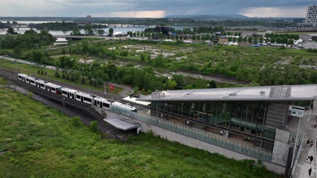 Aerial descent reveal of ottawa light rail train at station