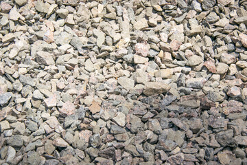 A close up photograph of a pile of gray and brown crushed stone gravel
