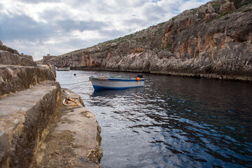 Fototapeta premium Boat for excursions to Blue Grotto on a cloudy day
