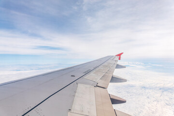 Obraz premium View from the airplane window at a beautiful cloudy sky and the airplane wing
