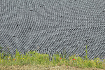 Many black, plastic shadow balls in the water. Shadow balls prevent water from evaporating.