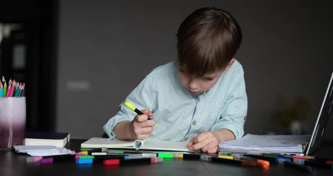 small boy doing homework at home focused and enthusiastic . Home education concept. High quality 4k footage