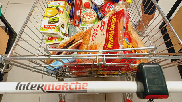 Intermarche shopping cart with groceries inside the supermarket