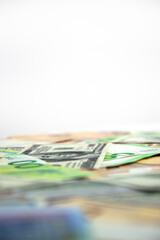 A close up shot of Euro and US dollar bills, with a white background. The bills are arranged in a haphazard manner, with some bills in focus and others out of focus