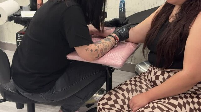Tattoo artist inking a client in a modern studio