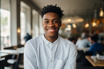 Fototapeta premium Portrait of a smiling young male waiter in restaurant