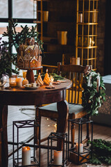 Family holiday celebration. Beautiful traditional homemade gingerbread house. Celebration of Christmas and Happy new year at home. Festive mood, cozy atmosphere, burning candles, fir tree branches