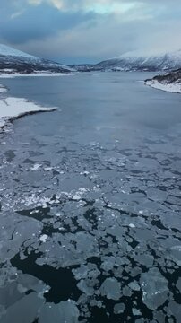 Winter aerial video over a frozen lake in nature in &Oslash;vre-Alta, Finnmark, Norway.