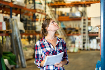 Fototapeta premium Portrait of caucasian woman working in warehouse, checking documentation.