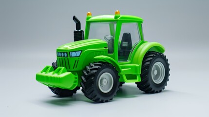 Green toy tractor on a white background. Plastic child toy. Construction vehicle. Toy tractor.