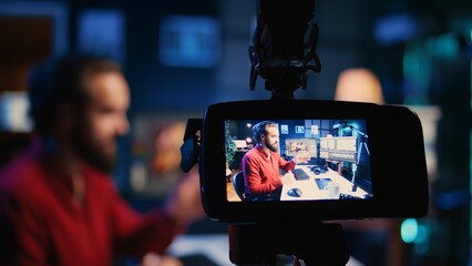 Focus on professional camera filming photographer in blurry background offering image retouching tips to viewers. Recording gear used by photo editor making online photography tutorial, close up