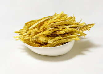 Close-up of stacked Hwangtae(dried pollack) pieces on dish and white floor, South Korea
