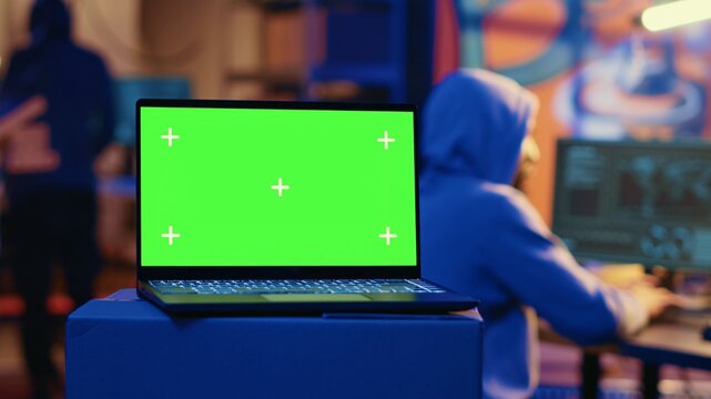 Green screen laptop used by hackers in underground hideout to write lines of code, developing virus that get past security systems. Chroma key device used by evil developers in hidden bunker