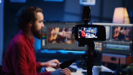 Professional camera equipment used by videographer in creative studio. Focus on video production gear in multimedia agency office used by post production editing expert in blurry background