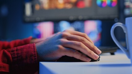 Extreme close up shot of video editor selecting key frames to use while doing video montage, working from home on computer. Man using mouse to edit movie project footage in office