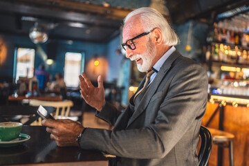 Senior man businessman business owner use digital tablet sit at cafe