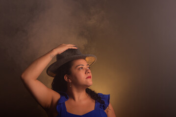 Beautiful curly-haired woman wearing a gray colored hat posing for the photo.