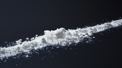 A close-up shot of a pile of white powder sitting on a black surface
