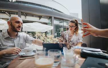 Startup team in business meeting discussing, brainstorming ideas, analyzing strategies at a modern outdoor cafe.