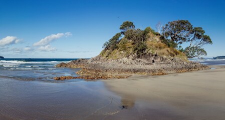 Rocky island on the shoreline beach of Opoutere, Whangamata, Coromandel Peninsula, New Zealand.