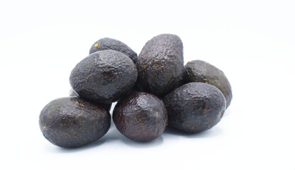 Hass avocado, alligator pear or avocado pear - Persea americana - whole and half prized for its large and unusually oily fruit and known for a huge pit seed, isolated on white background