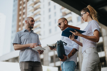 Team of marketing professionals having an outdoor meeting discussing campaign performance, market...