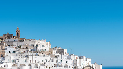 Naklejka premium Panorama of Ostuni, the white city, with the sea in the background.