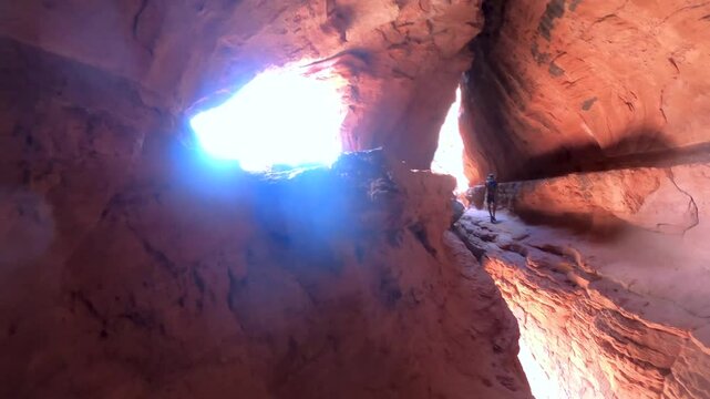 An unknown hiker is climbing the wall of the Soldiere Pass cave. The Soldier&rsquo;s Pass Cave is a unique place in the red rock country in Arizona.