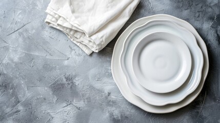 White napkins on grey cement background empty plates viewed from above