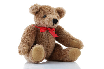 Obraz premium Brown Teddy Bear with a red bow sitting