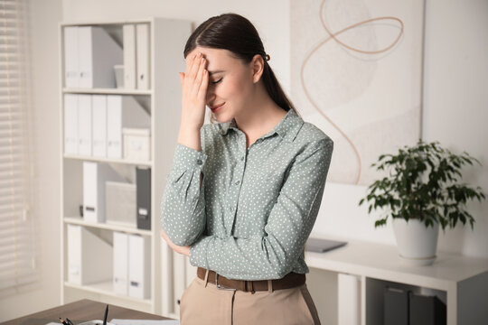 Portrait of embarrassed young woman in office