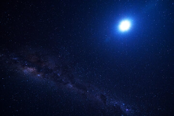 The Milky Way and the crescent moon are both visible.