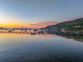 Sunrise over the calm water with boats and reflections