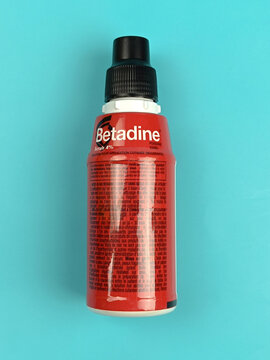 bouteille de b&eacute;tadine rouge de marque Mylan isol&eacute; sur un fond bleu