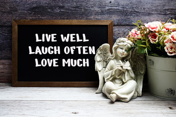 Inspirational quote Live wel Laugh often Love much text message written on chalkboard background