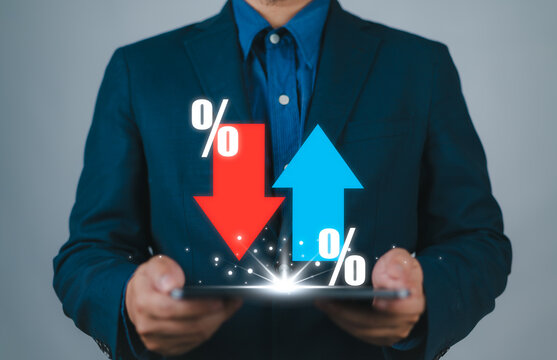 Businessman showing percentage icons and up and down arrow icons with graph indicators. Concept of financial interest rates and mortgage rates. Interest Rates Stocks Finance Ratings Mortgage Rates.