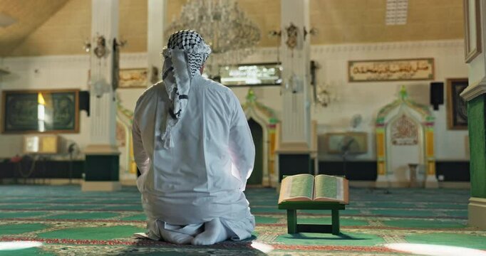 Muslim, man and prayer or dua in mosque for religious worship, spiritual faith or gratitude in praise. Back, islamic person or kneeling in holy temple and praying to Allah for Palestine in solidarity