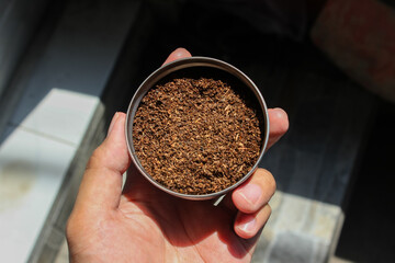 Hand puts a Tea leaf after blended and dried in the bowl. Tea Powder. Indonesian Tea