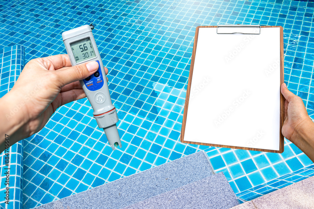 Wall mural Quality digital water tester with clipboard in girl hand over clear swimming pool water background, pool service and maintenance report