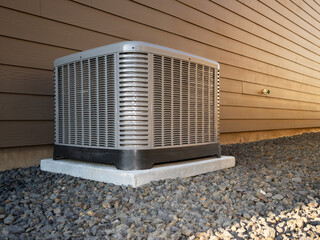 Modern HVAC air conditioner unit on concrete slab outside of duplex house.