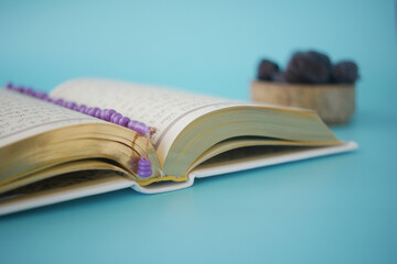 Holy book Quran and rosary on table, close up.