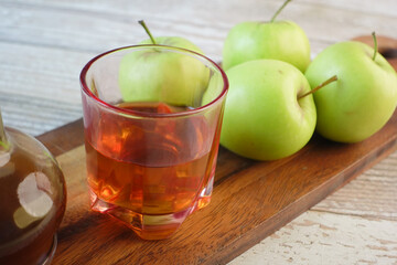 apple vinegar in glass bottle with fresh green apple on table 