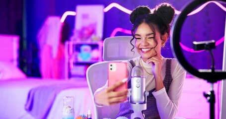 Selfie, influencer and woman with live streaming update in neon bedroom with social media audience, fans or followers. Excited content creator, gamer or streamer by mic, smartphone and gaming at home © CineLens2024/peopleimages.com
