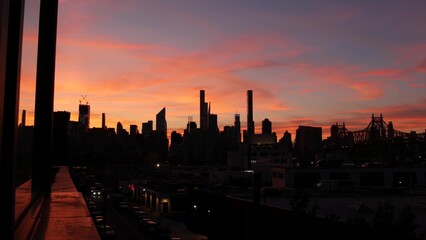 Fototapeta premium New York City Manhattan skyline cityscape. Rooftop in Queens, Midtown buildings, Queensboro Bridge. Sunset pink purple sky from roof in Long Island. Skyscrapers silhouette, high-rise architecture, NYC