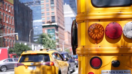 Yellow School Bus on New York Manhattan street, schoolbus truck on city road. Children education and transportation, USA. American school shuttle back view. Taxi cab, 10 avenue Chelsea, United States.