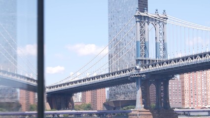 New York City Manhattan Bridge, Brooklyn waterfront, United States. Dumbo riverfront promenade by water, East river. USA travel destination. Cable-stayed bridge, riverside park, residential buildings.