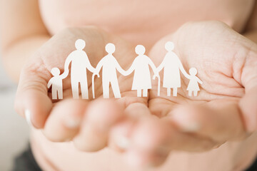 Hands holding multi generational family paper, family wellness, health insurance concept