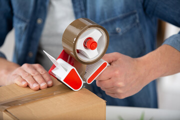close up of a guys hands holding packing machine